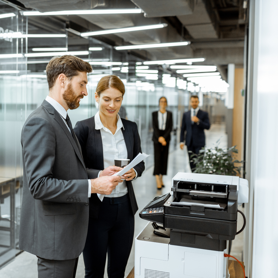 colleagues discussing at printer regarding managed print SLA in SA | Daisy