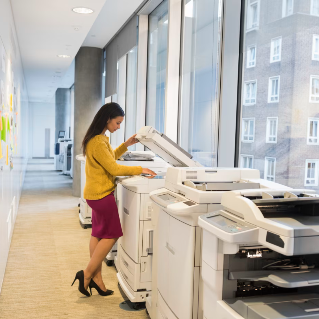 Lady standing in a Corporate office environment next to a multi-functional printer, busy scanning documents | Daisy Business Solutions