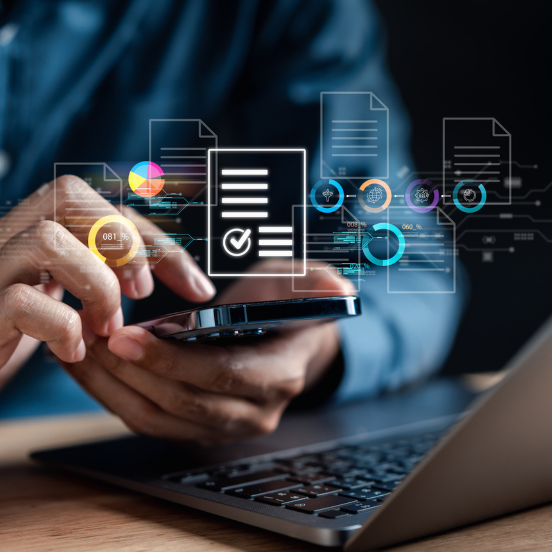 Client on their phone busy going through documentation next to a laptop at a desk | Daisy