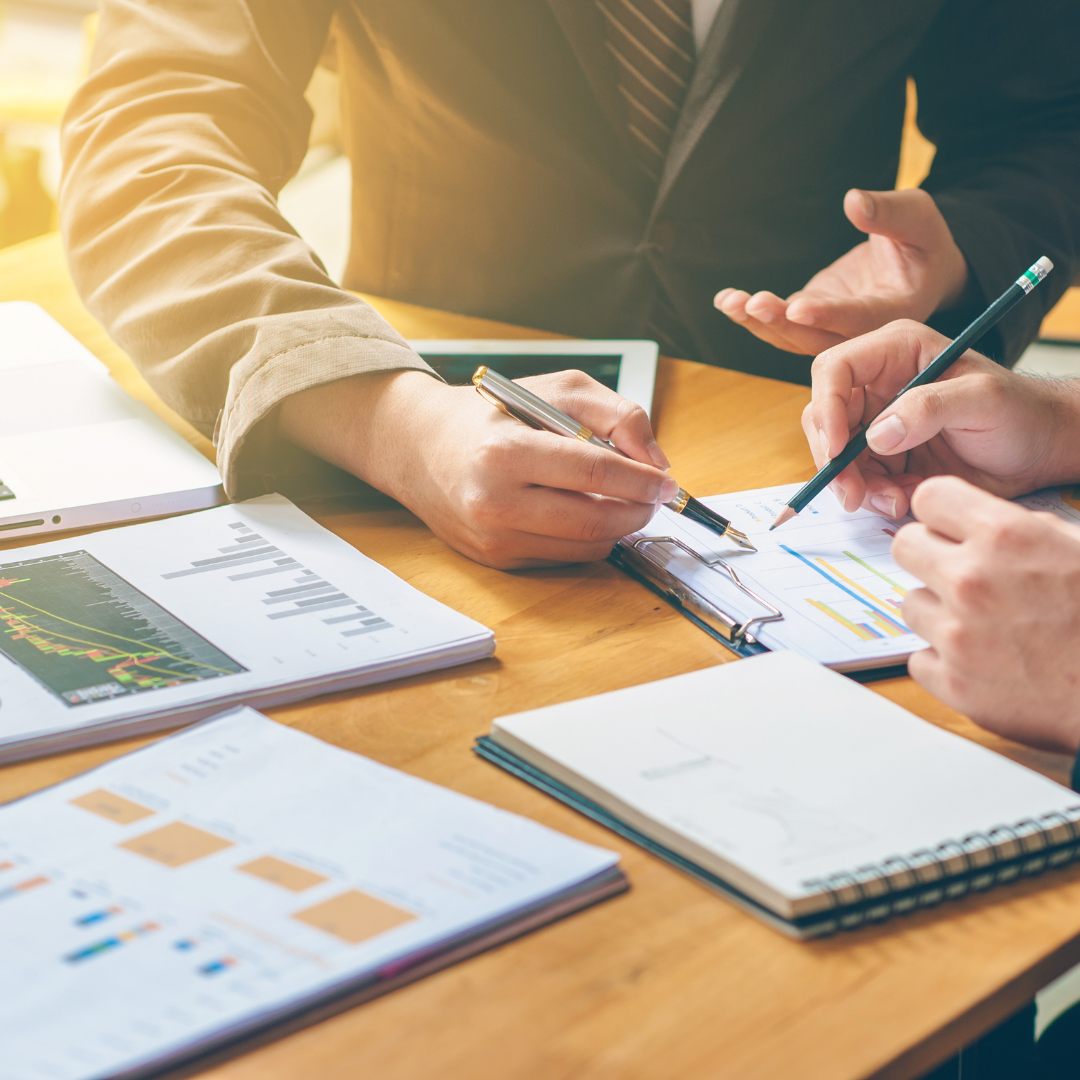 IT team sitting at the table and going through the papers discussing year-end system checks and disaster recovery for business.